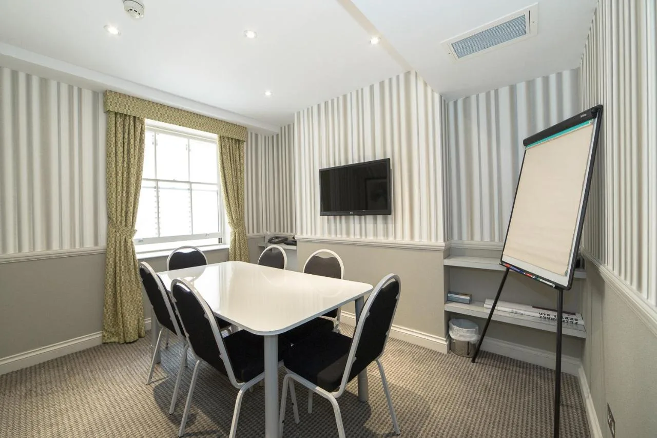 a meeting room with a table and chairs and a whiteboard at Phoenix Hotel in London