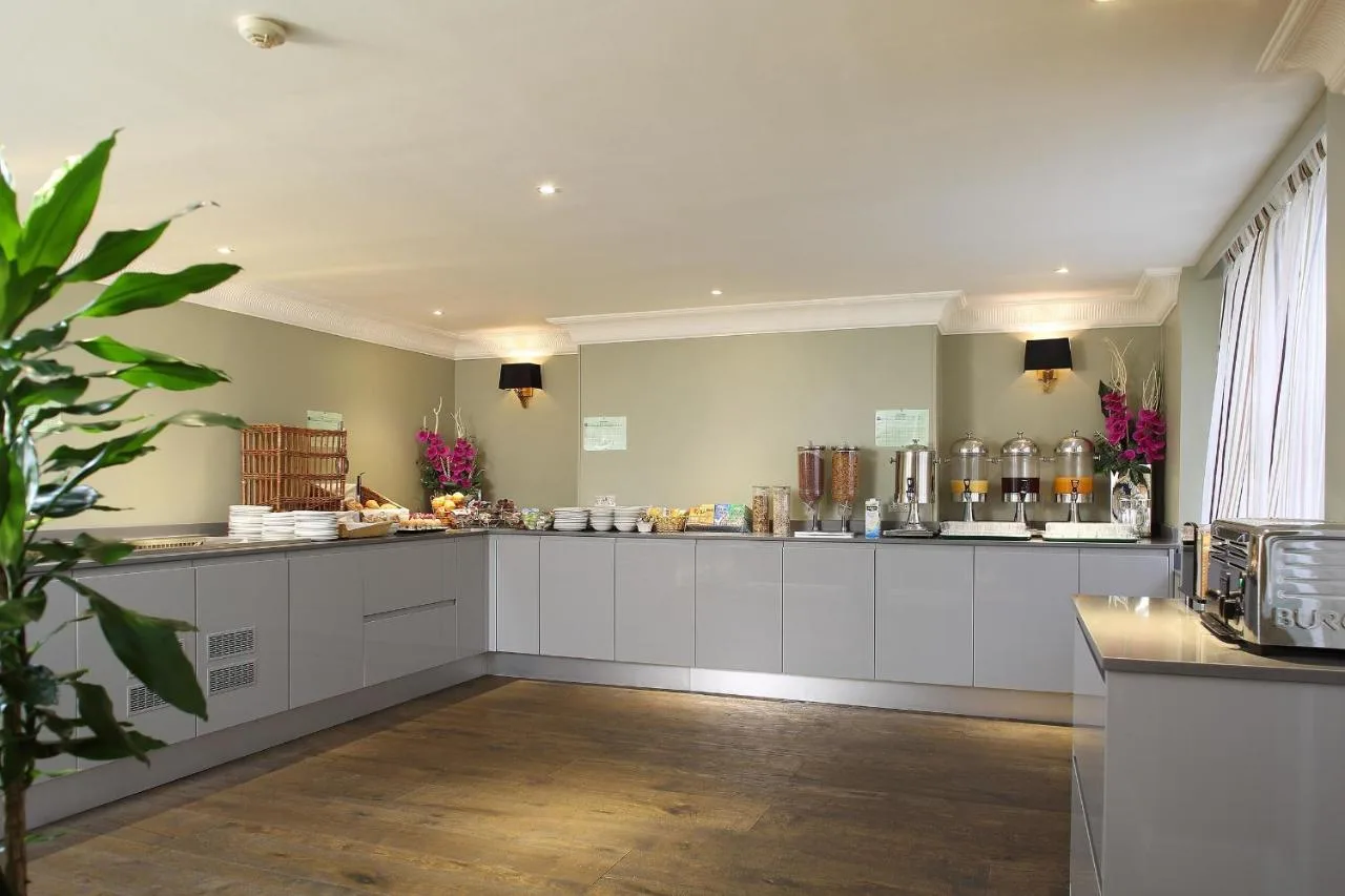 a kitchen with white cabinets and a counter top at Phoenix Hotel in London